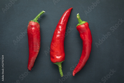 Red ripened Hungarian paprika hot chili peppers on a black background