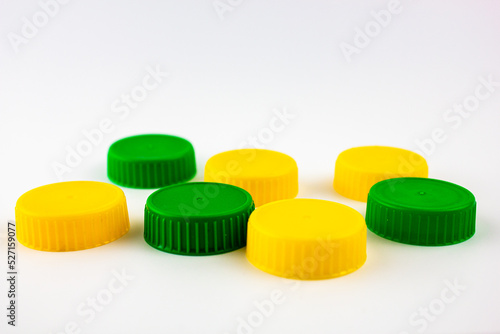 Plastic caps are green and yellow. Plastic caps from packaging, bottles.