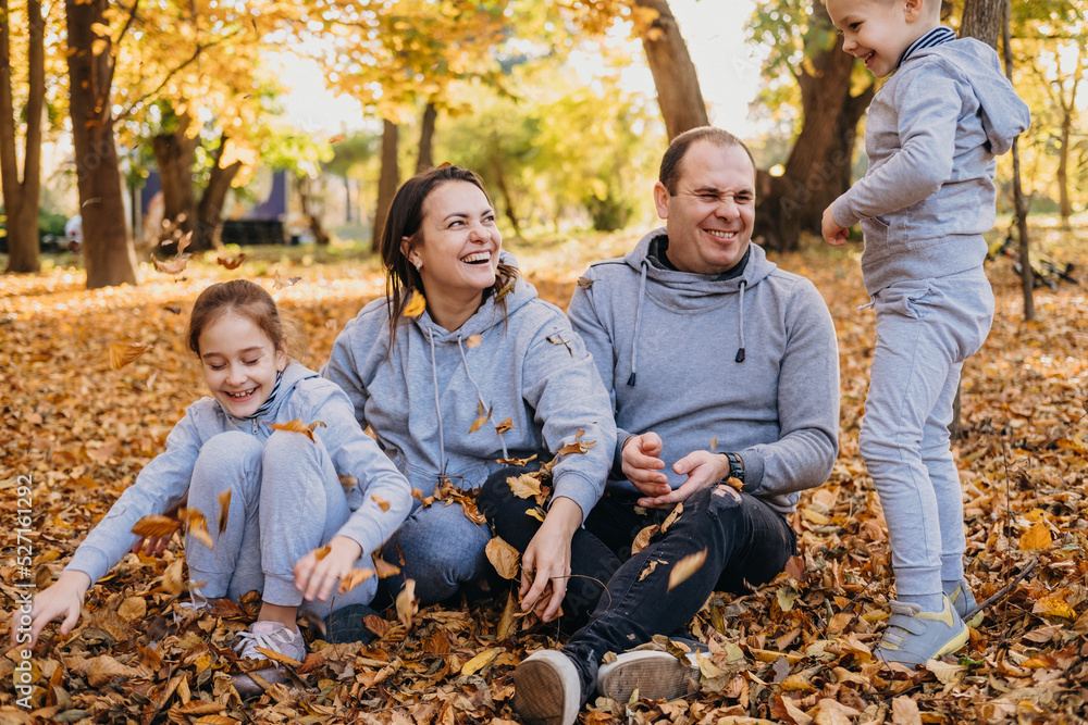 Family playing in autumn leaf pile on beautiful day, posing and recording memories. Family happiness love concept. Mother nature. Love people concept. Family Family playing in autumn leaf pile on beautiful day, posing and recording memories. Family happiness love concept. Mother nature. Love people concept. Family