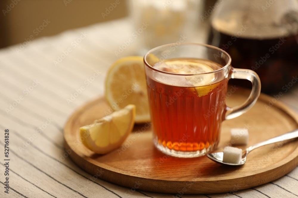 Glass mug of aromatic tea with lemon and sugar on table, closeup. Space for text Glass mug of aromatic tea with lemon and sugar on table, closeup. Space for text