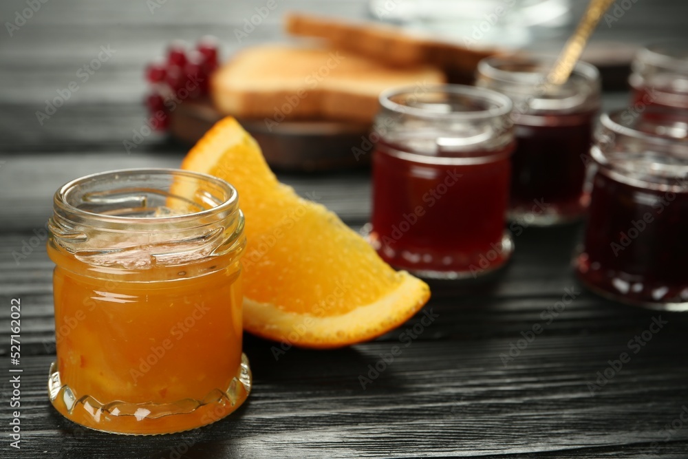 Jar of sweet orange jam on black wooden table, space for text Jar of sweet orange jam on black wooden table, space for text