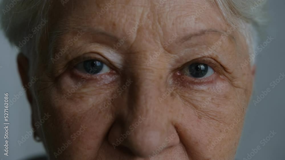 Close up portrait of beautiful older woman smiling and standing by wall with gray eyes. Close up portrait of beautiful older woman smiling and standing by wall with gray eyes.