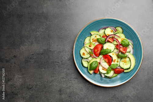 Tasty salad with cucumbers on grey table, top view. Space for text