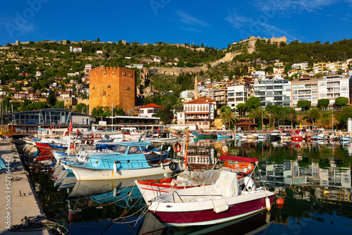 Pier of Alanya with moored boats. View of Kizil Kule (Red Tower) and Castle of Alanya, Antalya Province, Turkey. © JackF