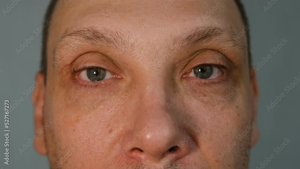 Middle-aged man face fragment, half man face, close up portrait of a middle aged man on grey background, grey eyes close up. Middle-aged man face fragment, half man face, close up portrait of a middle aged man on grey background, grey eyes close up.