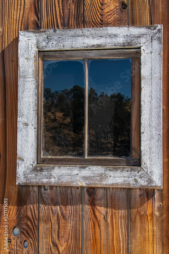 Weathered old wooden barn window in bright light