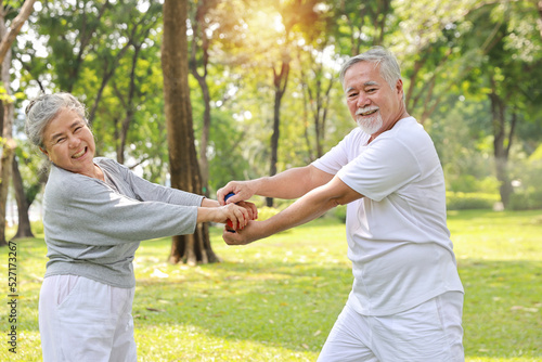 Happy and smiling asian senior couple doing arm work out and lifting dumbbell exercise with relaxation for healthy in park outdoor after retirement. Health care elderly outdoor lifestyle concept. © feeling lucky