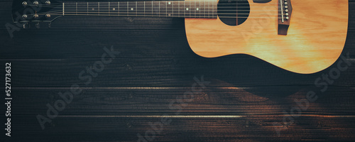 guitar on black wooden floor.