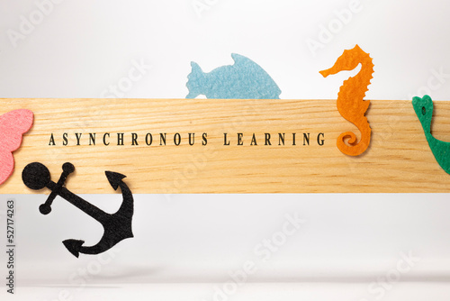 Asynchronous learning is written on a wooden patterned surface. Education and child psychology