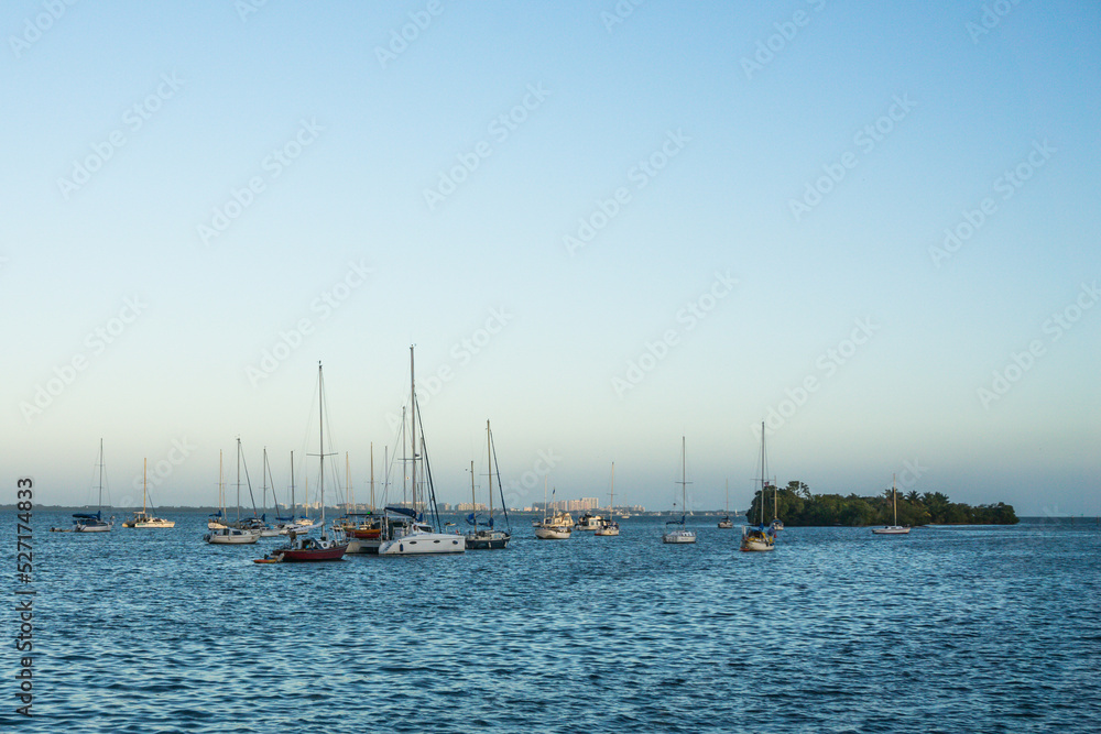 Seascape with a island and anchored sailboats at Miami, State of Florida, USA.