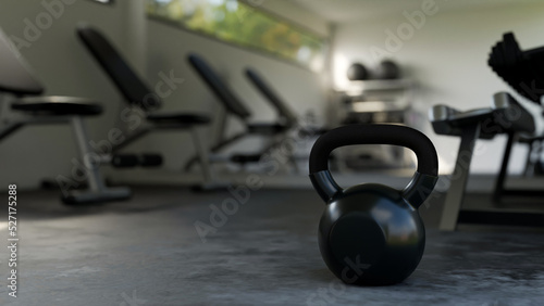 Kettle bell is on a gym floor over blurred modern professional fitness gym in the background.