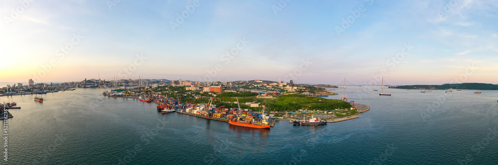 Residential buildings and berths of the Churkinsky district from above. Russian bridge. Ships are moored. A unique view from a drone on a summer evening - CIRCA 2022 Vlaivostok, Russia