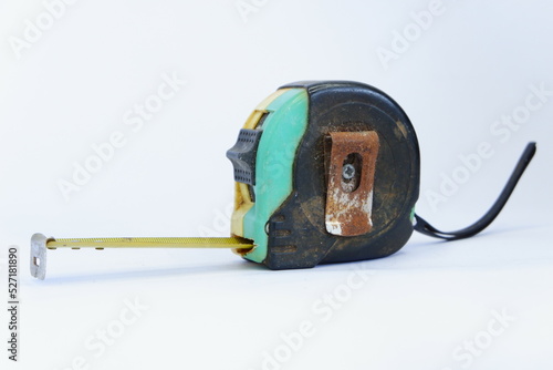 a used black, yellow, and green measuring tape isolated on white background, dirty measuring tape