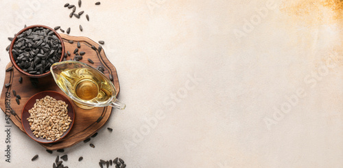 Sunflower oil and seeds on light background with space for text, top view