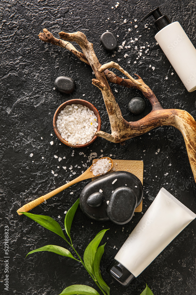 Beautiful spa composition with cosmetic products and sea salt on dark background Beautiful spa composition with cosmetic products and sea salt on dark background