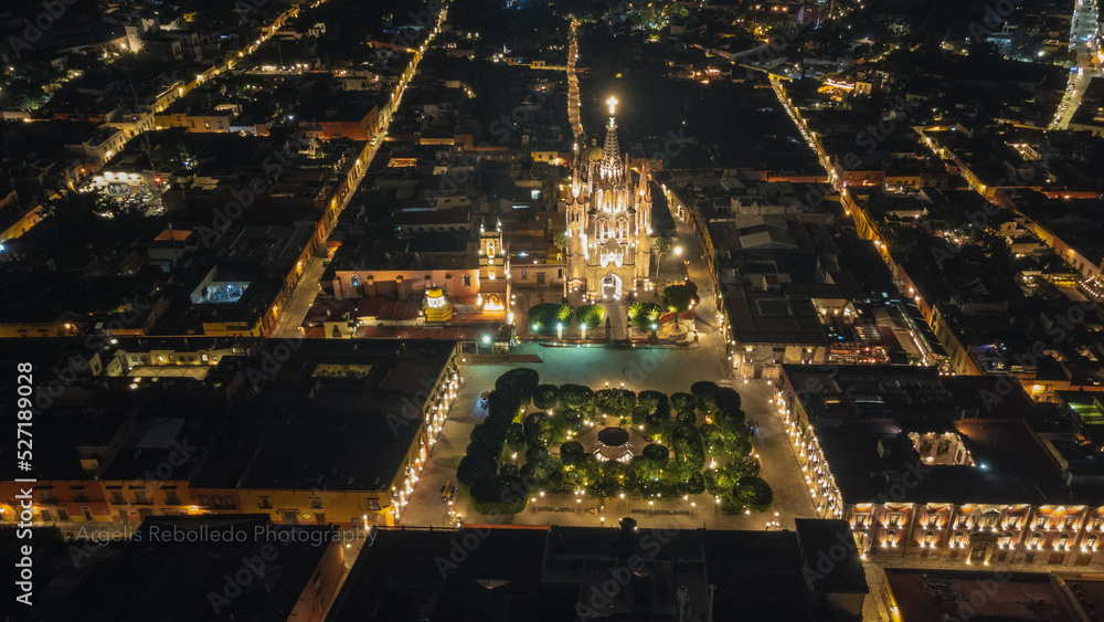 Obraz premium the church Parroquia Archangel Jardin Town Square Night Tree Decoraciones San Miguel de Allende, México. Parroaquia. Night and morning light in a drone view.