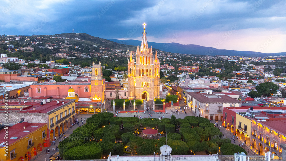 Obraz premium the church Parroquia Archangel Jardin Town Square Night Tree Decoraciones San Miguel de Allende, México. Parroaquia. Night and morning light in a drone view.