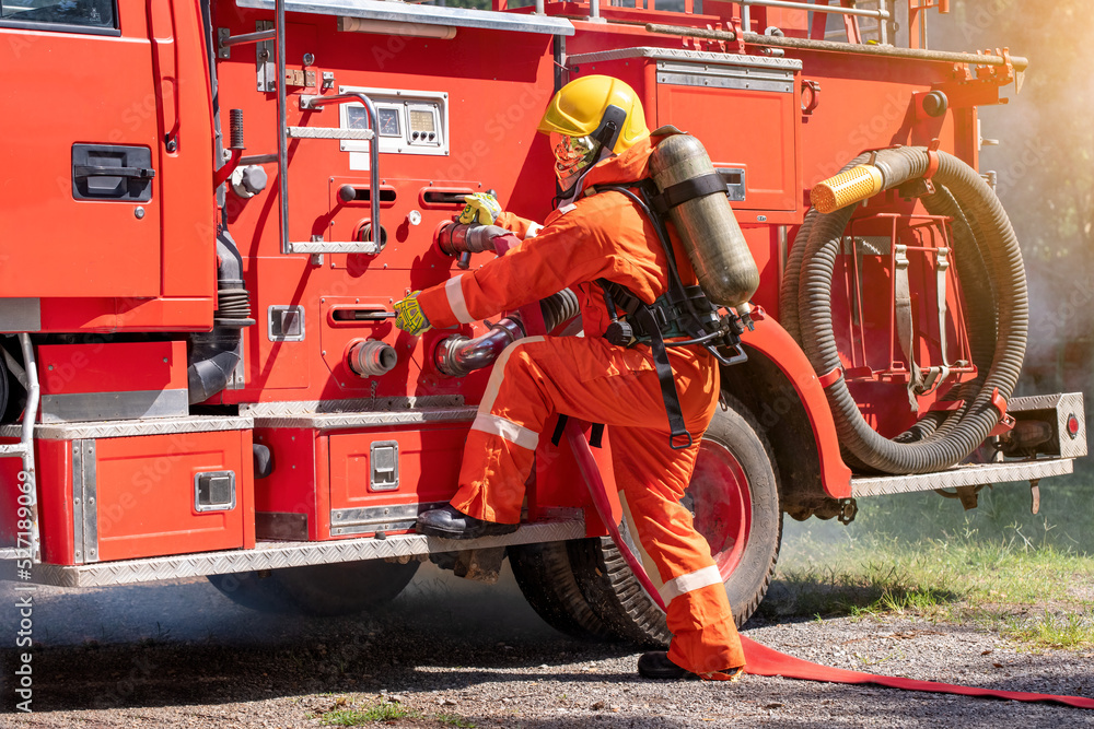 Firefighter man wearing protective fire suite and helmet with equipment and accessories is fire safety accident protection is industry safety concept. Firefighter man wearing protective fire suite and helmet with equipment and accessories is fire safety accident protection is industry safety concept.