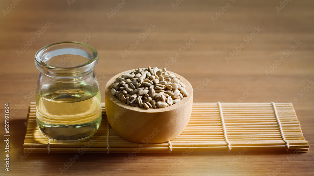 Organic sunflower seeds and sunflower oil on wooden table Organic sunflower seeds and sunflower oil on wooden table