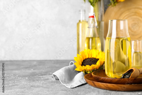 Plates with bottle of oil  scoop and sunflower seeds on light background