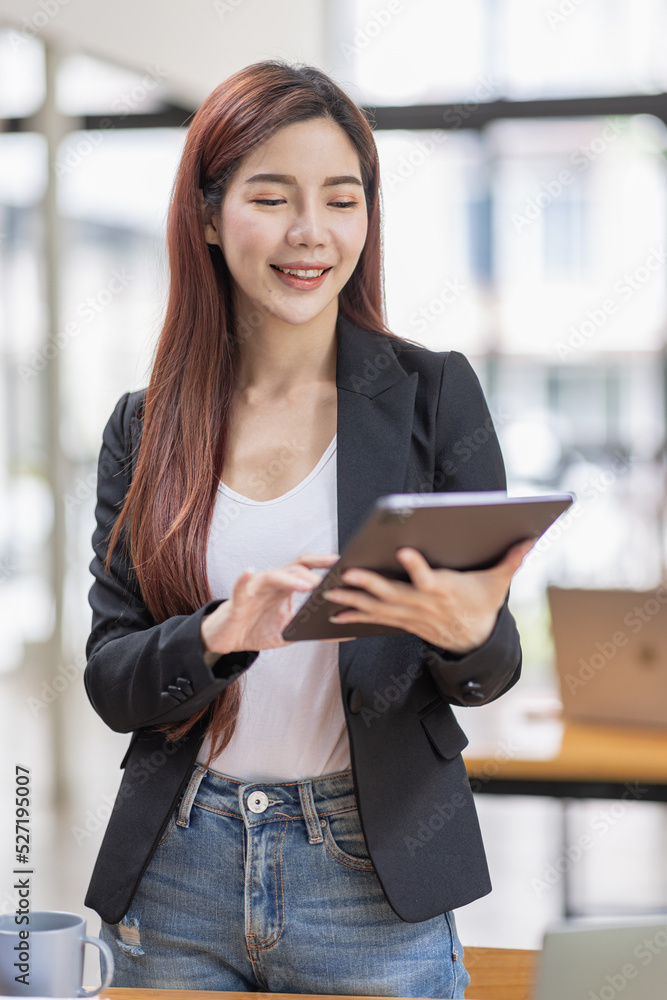 Business Asian Female holding tablet laptop and steanding in the workplace, concept of business accounting documents planning finance analysis and report, Business Asian Female holding tablet laptop and steanding in the workplace, concept of business accounting documents planning finance analysis and report,