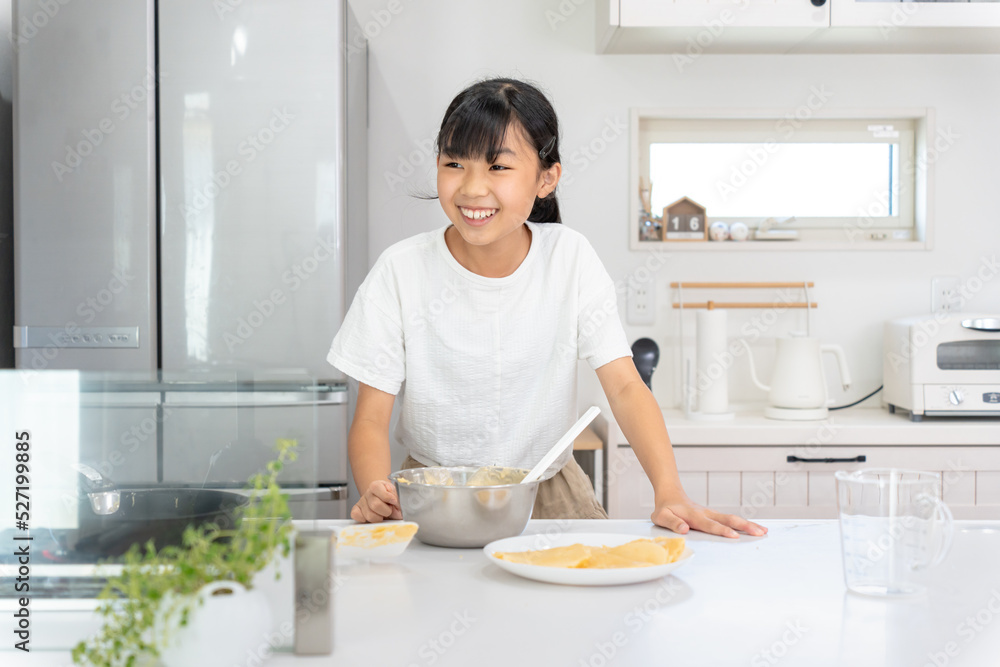 自宅のキッチンで料理をしているアジア人の女子 自宅のキッチンで料理をしているアジア人の女子