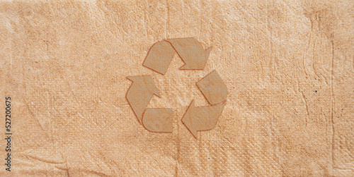 Brown recycling symbol on brown recycle paper with texture of toilet paper. Paper illustration for save the planet and energy concept.