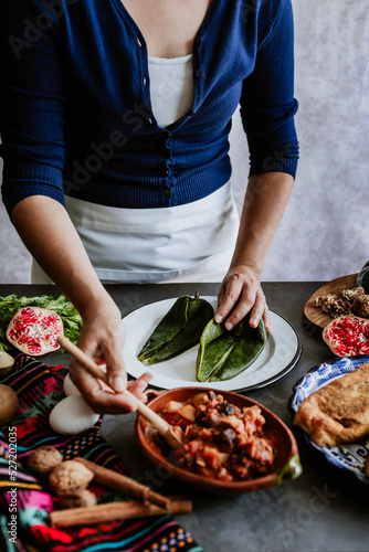 mexican woman hands preparing and cooking chiles en nogada recipe with Poblano chili and ingredients, traditional dish in Puebla Mexico 