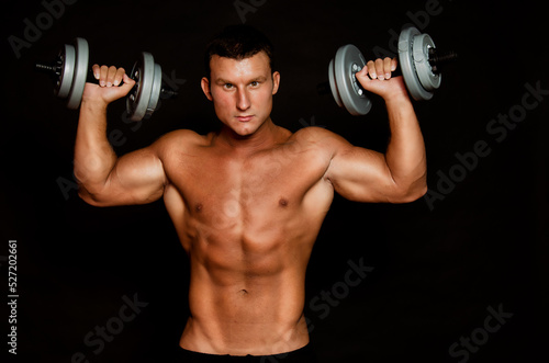 Young athletic man goes in for sports in the gym. © vladorlov