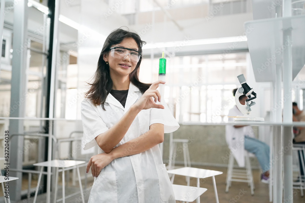Young scientist in white lab coat working with binocular microscope in the material science lab Young scientist in white lab coat working with binocular microscope in the material science lab