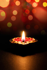 Happy Diwali. Diya lamp lit, dark bokeh light. Deepavali Hindu holiday celebration