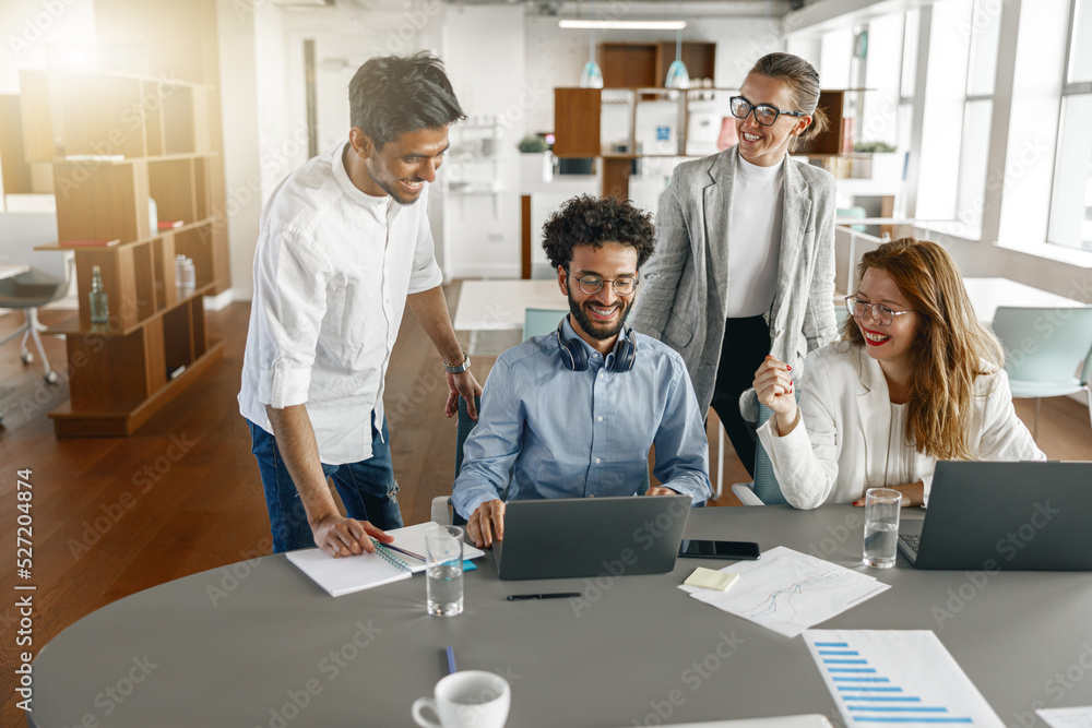 Happy coworkers cooperating and working together at office meeting, teamwork concept Happy coworkers cooperating and working together at office meeting, teamwork concept