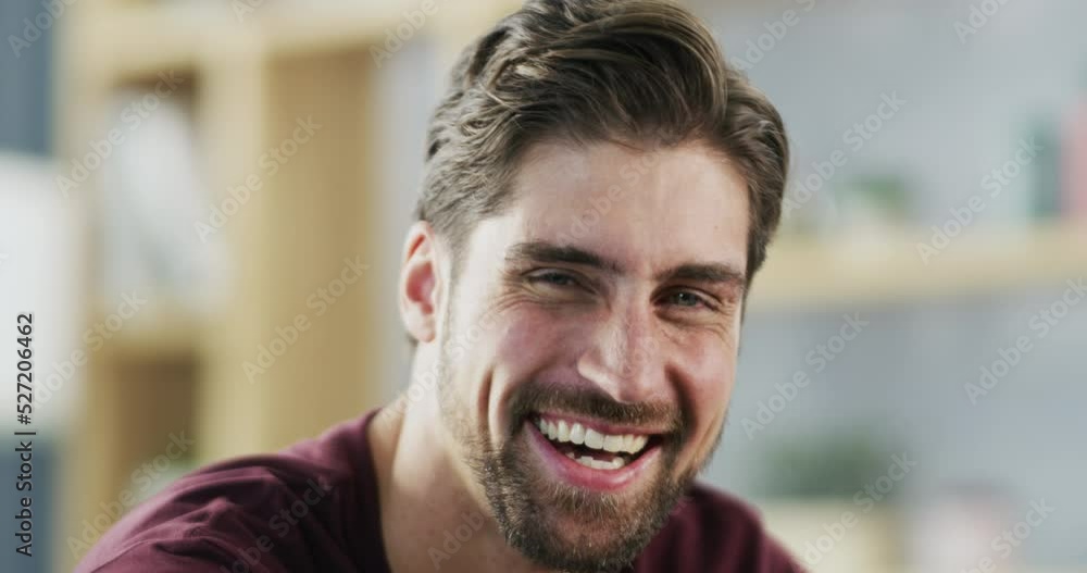 Laughing, happy and smile of a man with a comic, funny and relax mindset in his home living room. Portrait of a male with happiness and positive laughter hearing a joke or comedy routine in a lounge Laughing, happy and smile of a man with a comic, funny and relax mindset in his home living room. Portrait of a male with happiness and positive laughter hearing a joke or comedy routine in a lounge