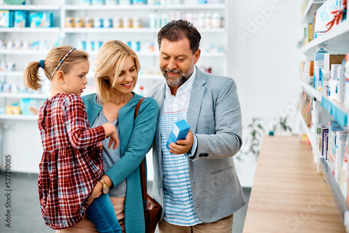 Obraz na plátně Happy family shopping together in pharmacy.