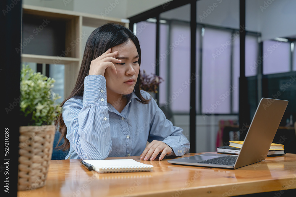 Stressed asian woman working from home on laptop looking worried, tired and overwhelmed. Stressed asian woman working from home on laptop looking worried, tired and overwhelmed.