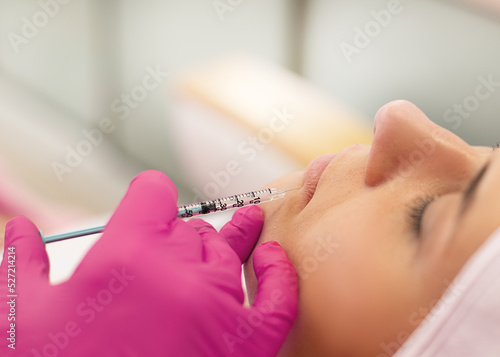Photos Close-up of young woman getting beauty injection into lips