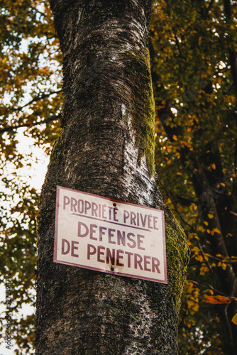 Sign on a tree translating Private property no entry in french