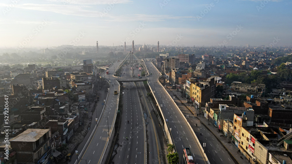 An early morning aerial image of the Aazadi Chowk Interchange, located near the old city which includes historical landmarks of Lahore Fort and the famous Badshahi Mosque - Cinematic Edit