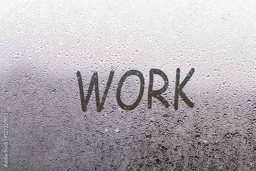 the word work written on night wet window glass close-up with blurred background photo