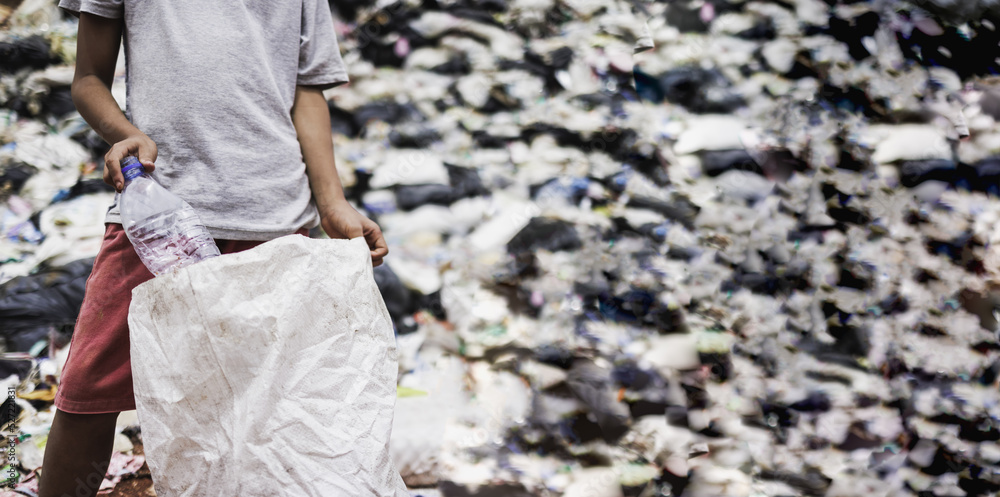 Foto de A young poor Indian boy collection waste plastic bottles in his ...