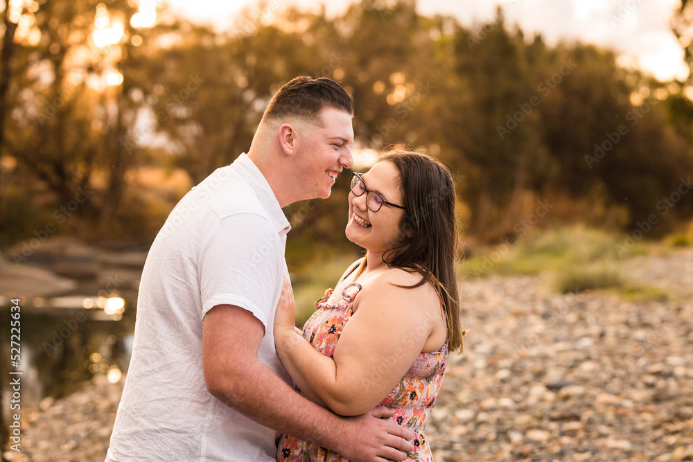 Man leaning in to whisper in partner's ear laughing Man leaning in to whisper in partner's ear laughing