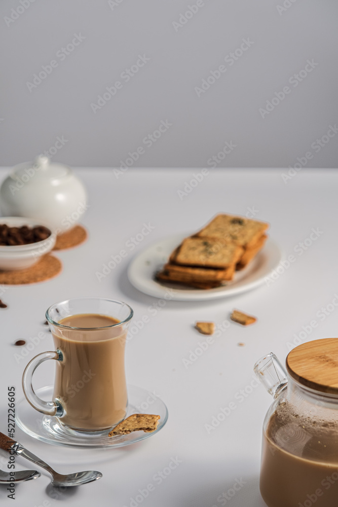 Obraz premium a cup of coffee with milk on a light background, a light breakfast for children, healthy and healthy food, coffee and dry biscuits, bran cracker, top view with copy space 