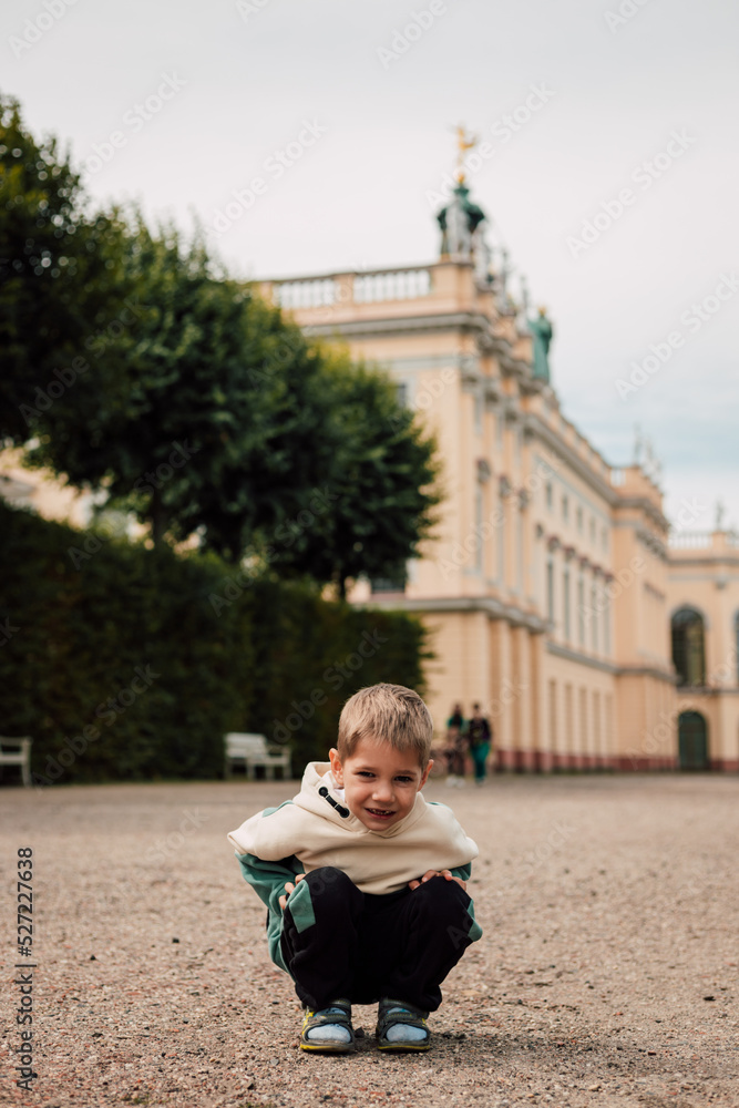 A little boy in a tracksuit stands on a large square in Europe A little boy in a tracksuit stands on a large square in Europe