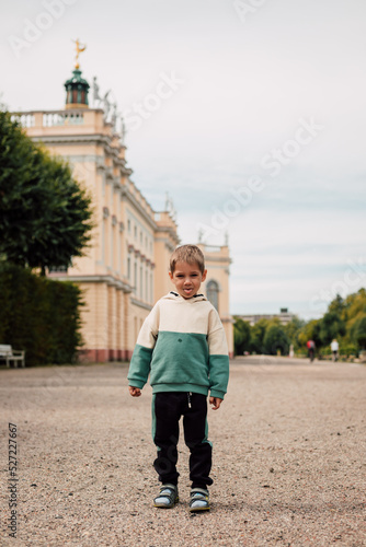 A little boy in a tracksuit stands on a large square in Europe © Ирина Санжаровская