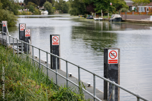 No swimming signs attached to posts on a dangerous section of the River Thames