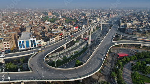 A closeup and an aerial image of Aazadi Chowk's famous interchange and flyover, with its populated neighborhoods in the background.