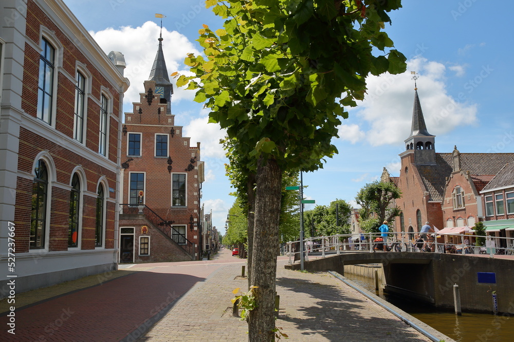 Fototapeta premium The historical center of Balk, Friesland, Netherlands, with historic houses, canals, the Raadhuis (former town hall on the left) and Breahus church (on the right)