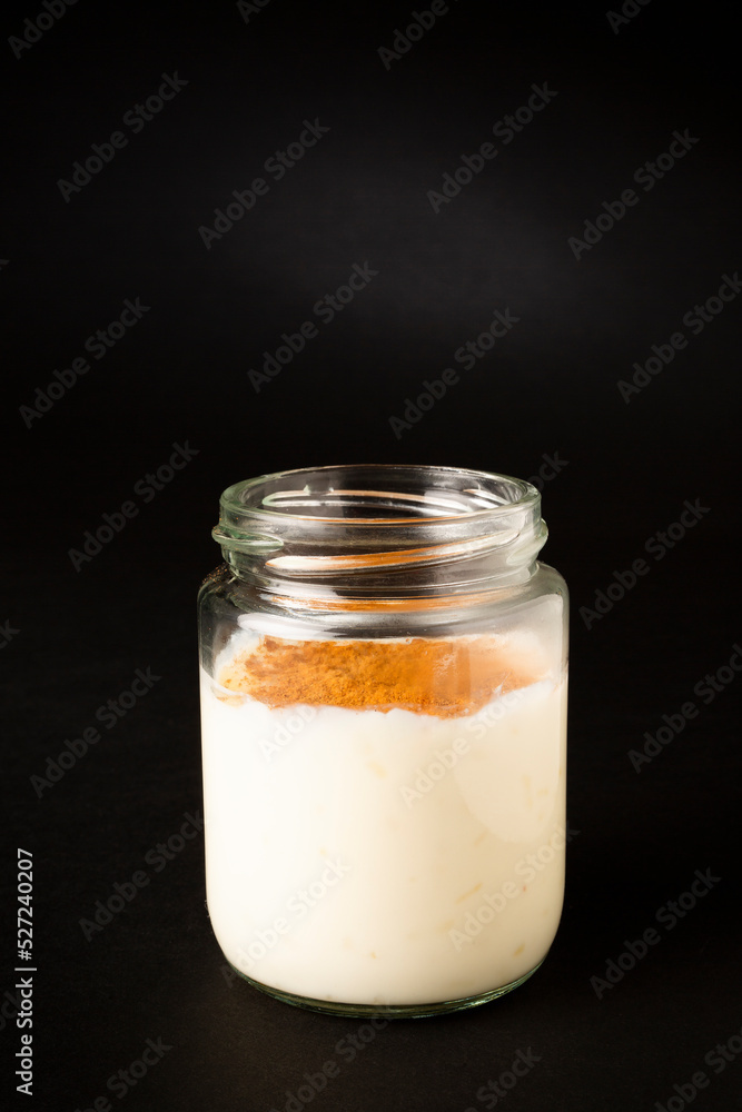 Homemade rice pudding in a glass pot over a black background Homemade rice pudding in a glass pot over a black background