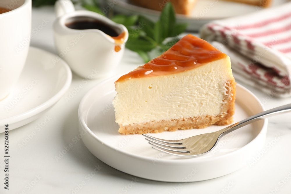 Piece of delicious caramel cheesecake served on white marble table, closeup Piece of delicious caramel cheesecake served on white marble table, closeup