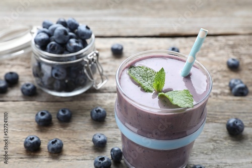 Freshly made blueberry smoothie on wooden table, closeup. Space for text
